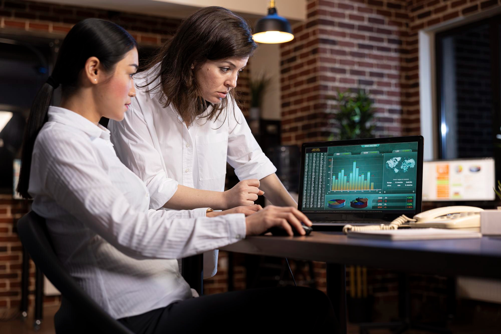 Two professionals reviewing financial workflow data